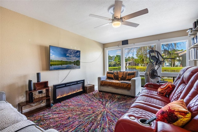 living room with ceiling fan and a textured ceiling