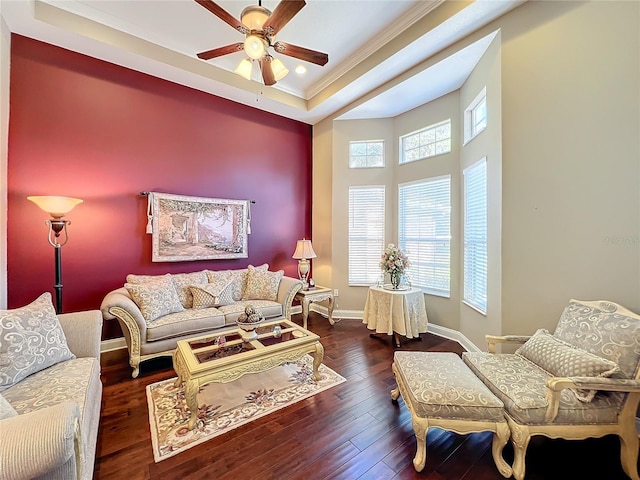 living room featuring ornamental molding, ceiling fan, dark hardwood / wood-style floors, and a tray ceiling