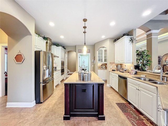 kitchen featuring sink, white cabinetry, pendant lighting, stainless steel appliances, and a kitchen island with sink