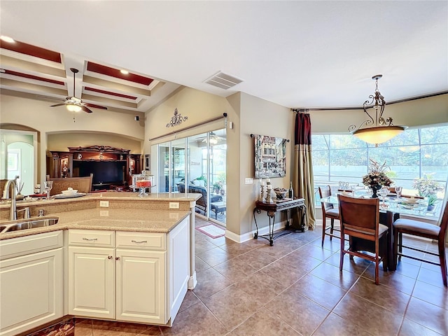 kitchen featuring sink, hanging light fixtures, a healthy amount of sunlight, and coffered ceiling