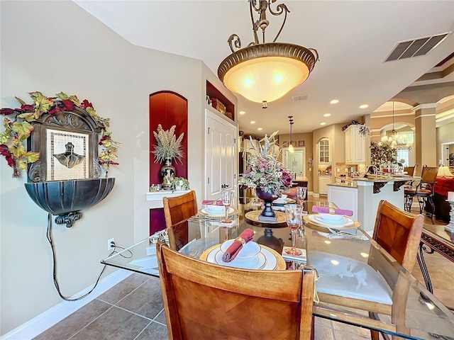 dining space with tile patterned flooring and an inviting chandelier