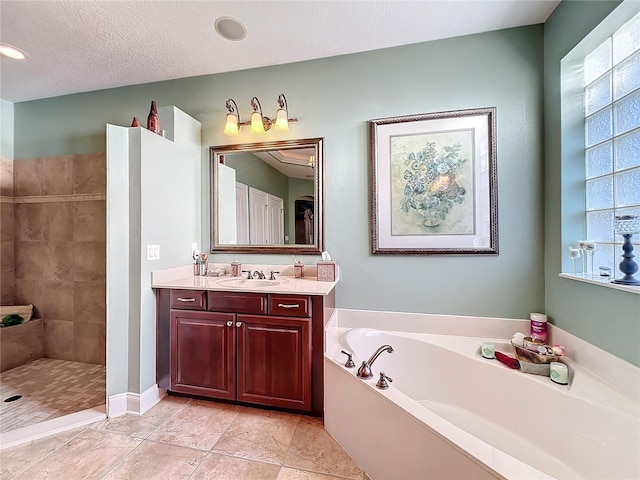 bathroom featuring a textured ceiling, vanity, and independent shower and bath