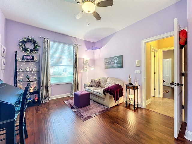 living room featuring ceiling fan and dark hardwood / wood-style flooring