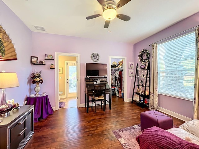 living room with dark hardwood / wood-style flooring and ceiling fan