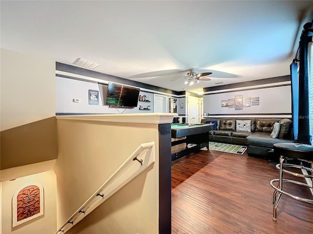 living room featuring ceiling fan and dark hardwood / wood-style flooring