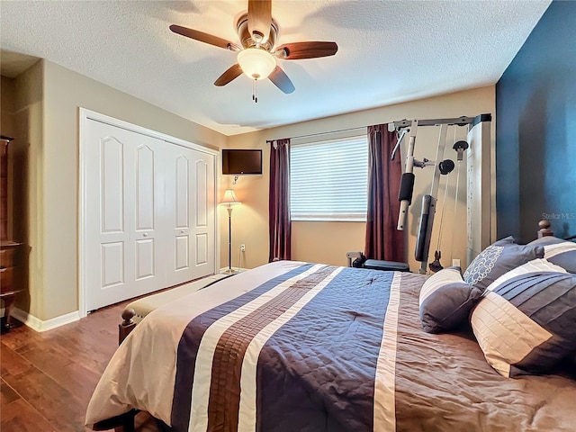 bedroom featuring ceiling fan, light hardwood / wood-style floors, a textured ceiling, and a closet