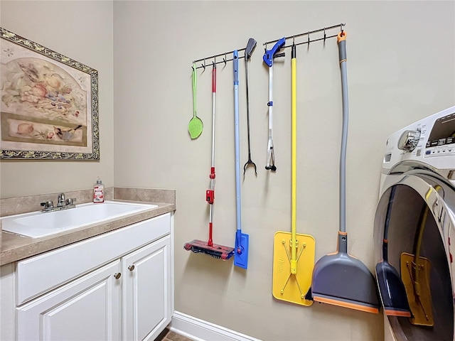 laundry room with cabinets, sink, and washer / dryer