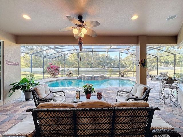 view of pool featuring a patio area, an in ground hot tub, ceiling fan, an outdoor living space, and a lanai