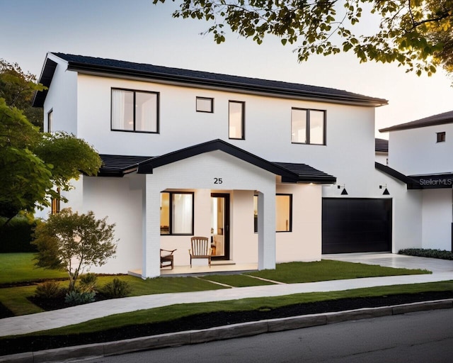 modern farmhouse style home with a garage, concrete driveway, and stucco siding