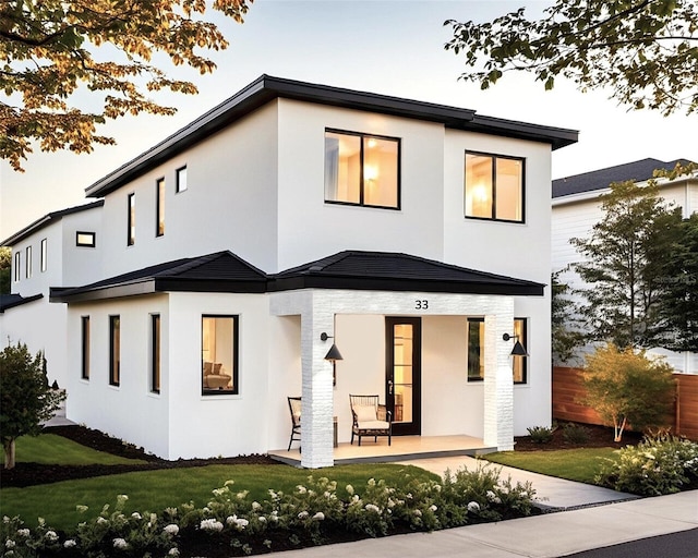 back of house featuring a lawn and stucco siding