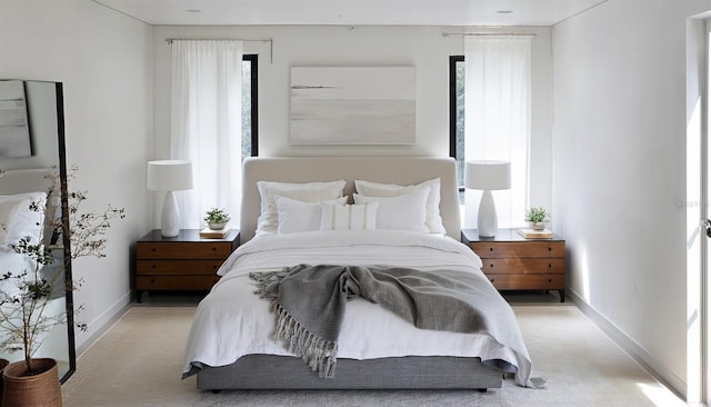 bedroom with light colored carpet and baseboards