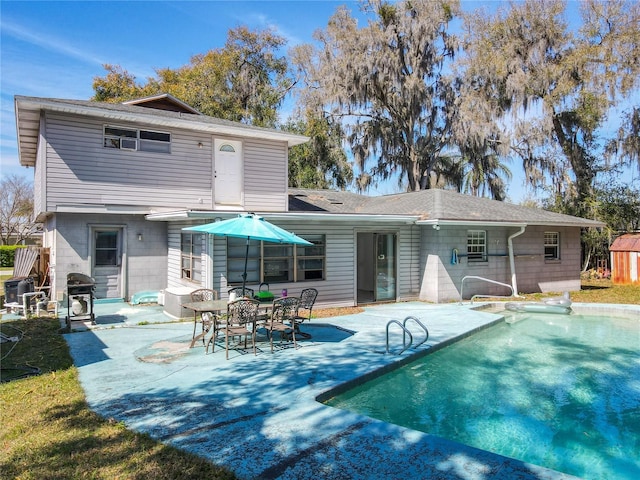 rear view of house featuring an outdoor pool and a patio