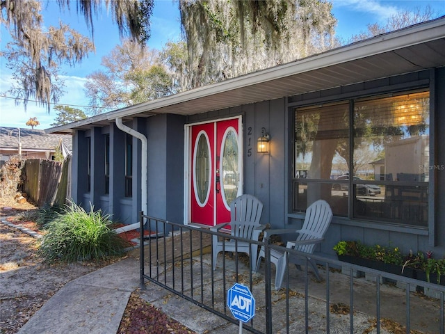 doorway to property featuring fence