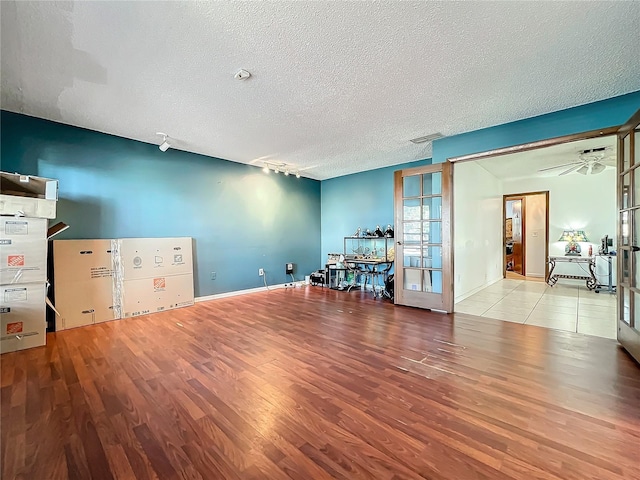 spare room with french doors, visible vents, a textured ceiling, wood finished floors, and baseboards