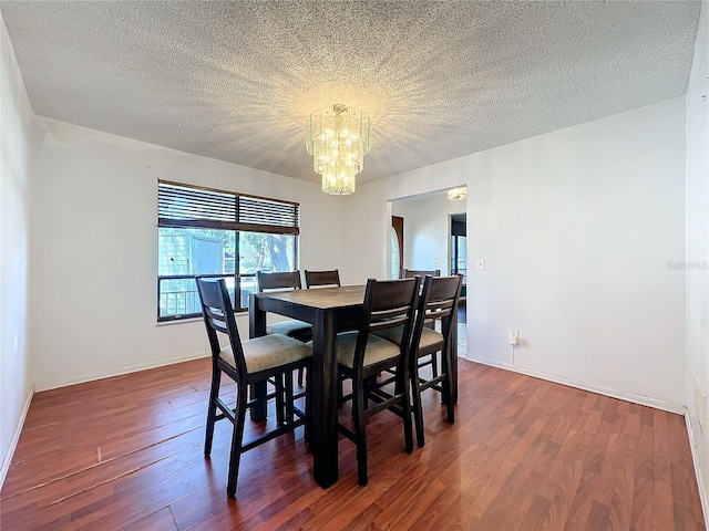 dining space with baseboards, a textured ceiling, a chandelier, and dark wood-type flooring