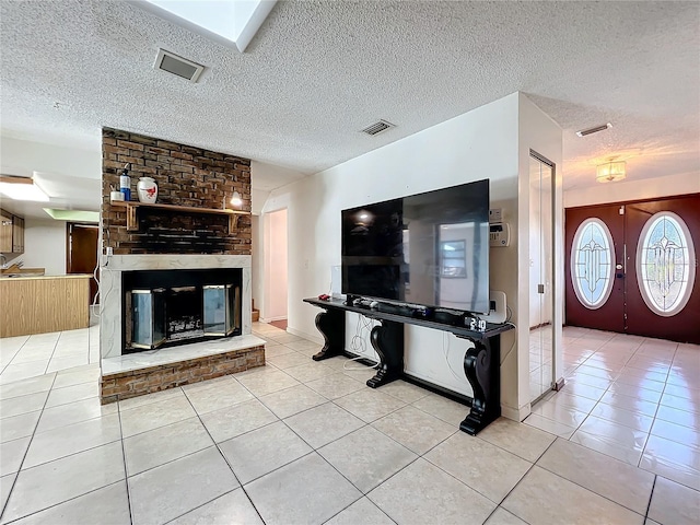 living area with light tile patterned floors, a fireplace, and visible vents