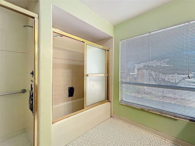 bathroom with bath / shower combo with glass door and tile patterned floors