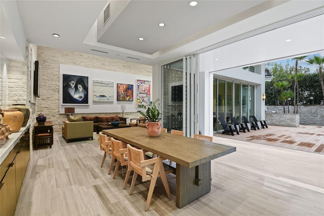 dining space featuring a tray ceiling, light wood-style flooring, recessed lighting, and visible vents