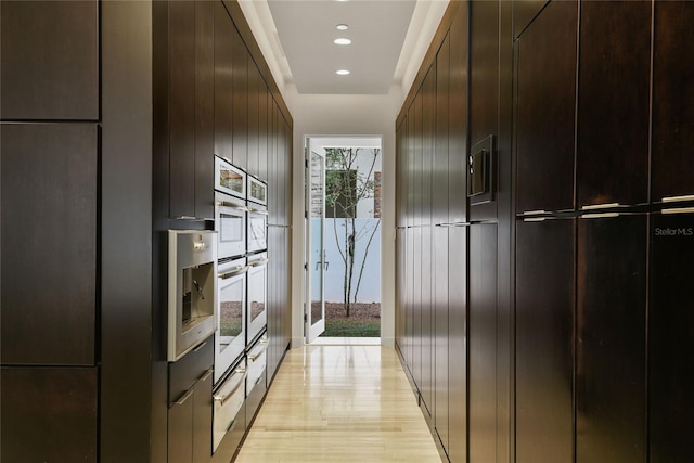 kitchen featuring a warming drawer, modern cabinets, light wood-style flooring, recessed lighting, and dark brown cabinetry