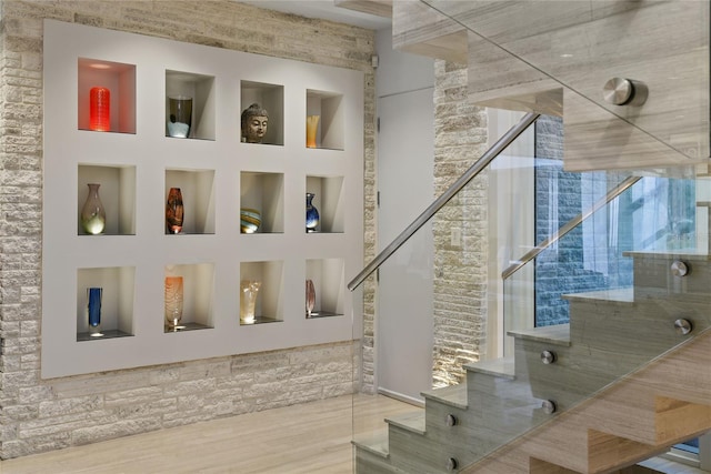 stairway with built in features and wood finished floors