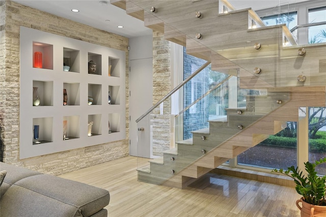 staircase featuring built in features and wood finished floors