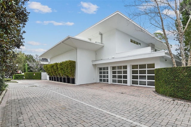 exterior space with stucco siding and decorative driveway