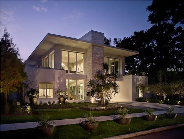 view of front of house with a balcony and stucco siding