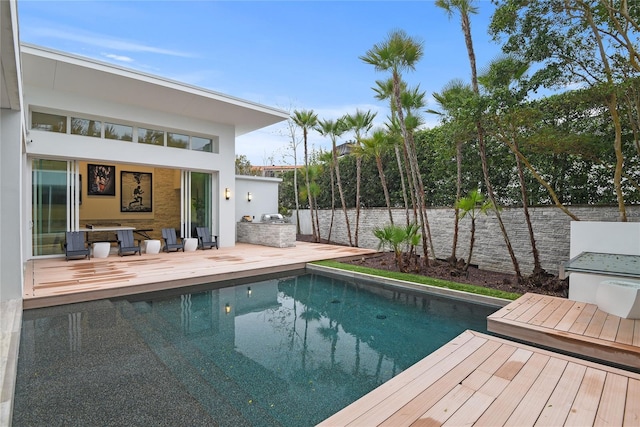 view of pool with area for grilling, a fenced in pool, a deck, and fence