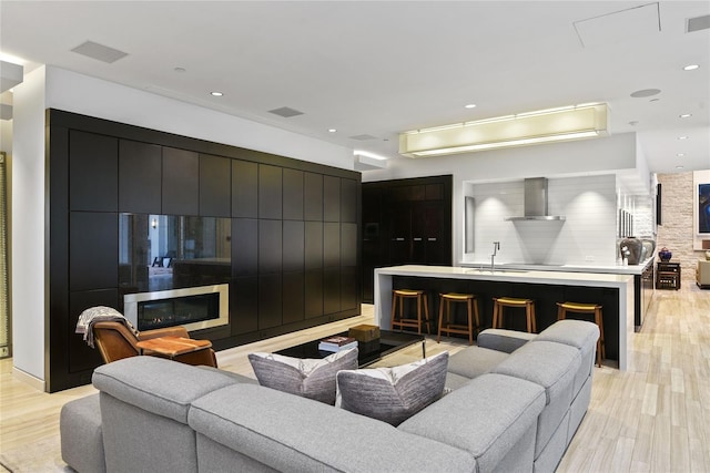living room featuring recessed lighting, light wood-style flooring, and visible vents