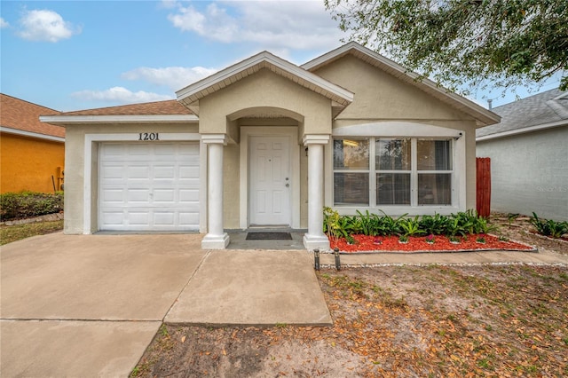 single story home with a garage, driveway, and stucco siding