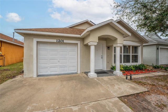 ranch-style home featuring driveway, an attached garage, roof with shingles, and stucco siding