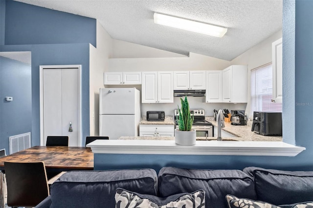 kitchen featuring electric stove, visible vents, freestanding refrigerator, white cabinetry, and a sink