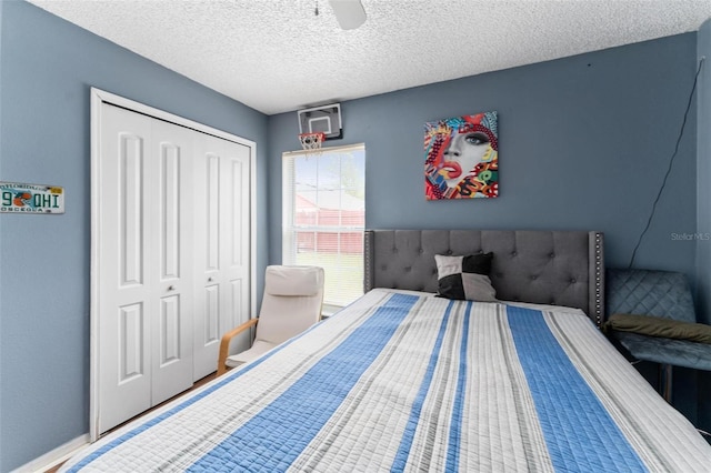 bedroom featuring a textured ceiling, a ceiling fan, and a closet