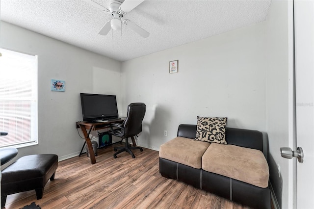 office featuring a textured ceiling, ceiling fan, wood finished floors, and baseboards