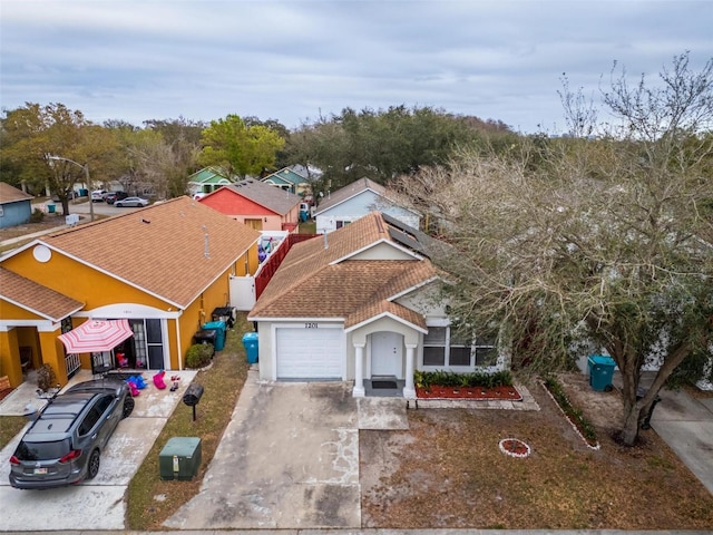 exterior space with concrete driveway, a shingled roof, and an attached garage