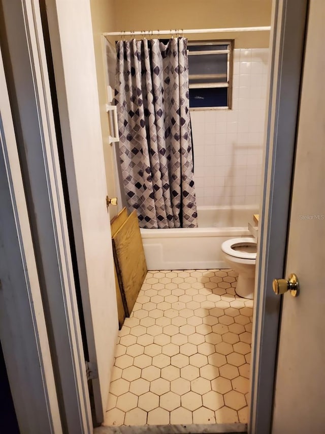 bathroom with toilet and shower / bath combo with shower curtain