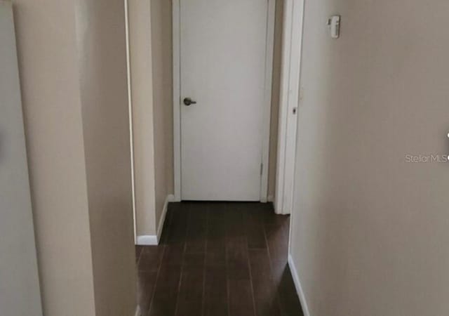 hallway with dark hardwood / wood-style flooring