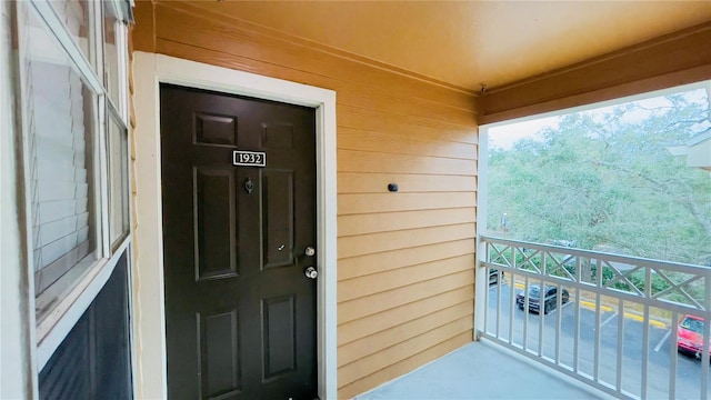 view of exterior entry featuring a balcony