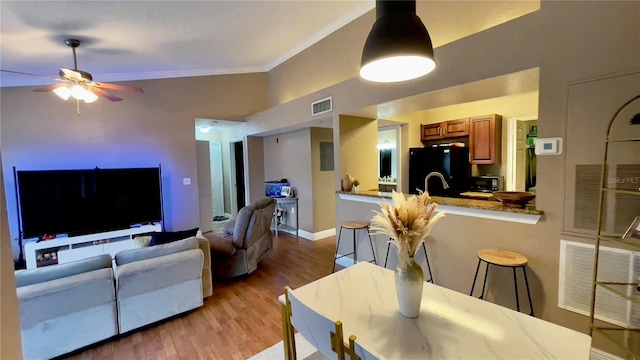 living room featuring ceiling fan, ornamental molding, and light hardwood / wood-style floors