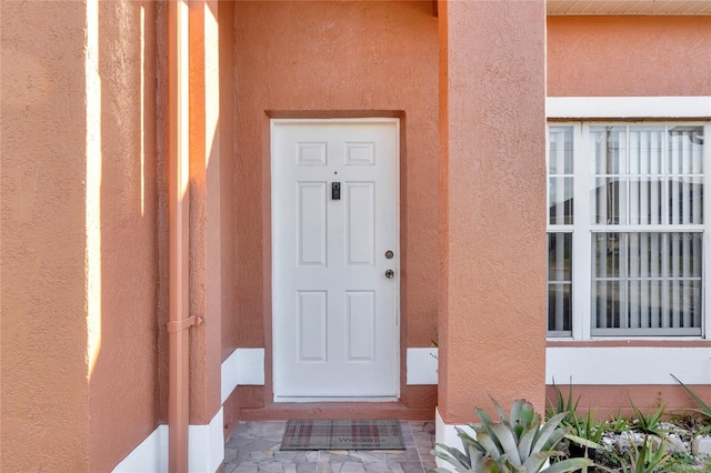 view of exterior entry featuring stucco siding