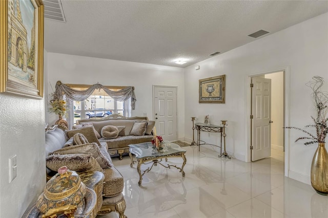 living area featuring visible vents, a textured ceiling, and baseboards