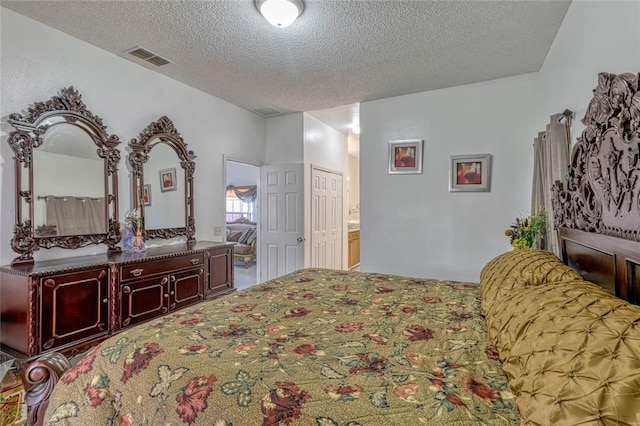 bedroom with a textured ceiling and visible vents