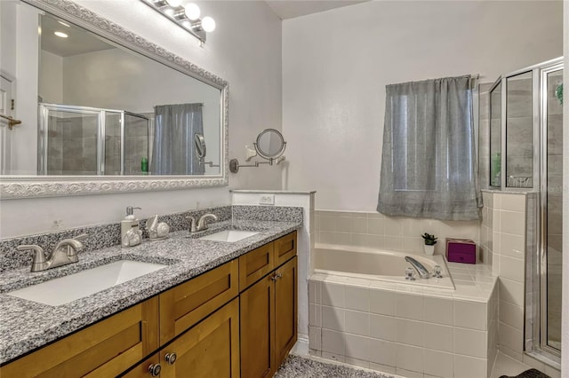 bathroom featuring a garden tub, a sink, a shower stall, and double vanity