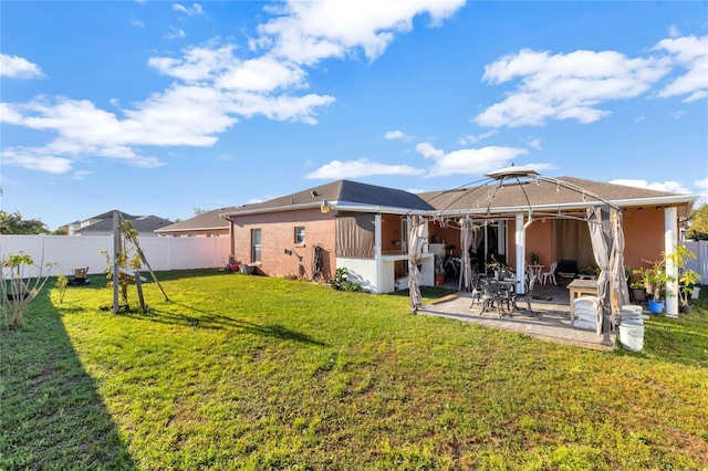 back of house featuring a patio, a lawn, and a fenced backyard