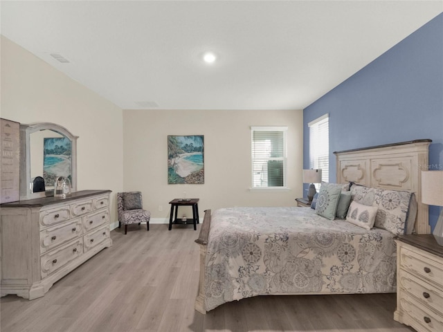 bedroom with light wood finished floors and baseboards