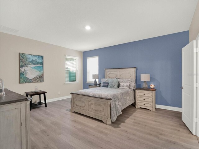 bedroom featuring baseboards, visible vents, and light wood-style floors