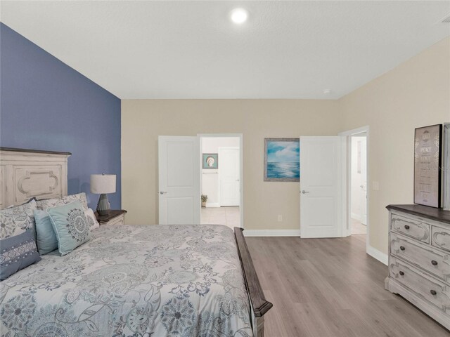 bedroom with light wood-type flooring and baseboards