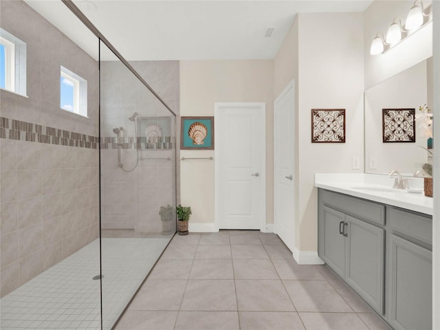 full bath featuring a walk in shower, visible vents, vanity, and tile patterned floors