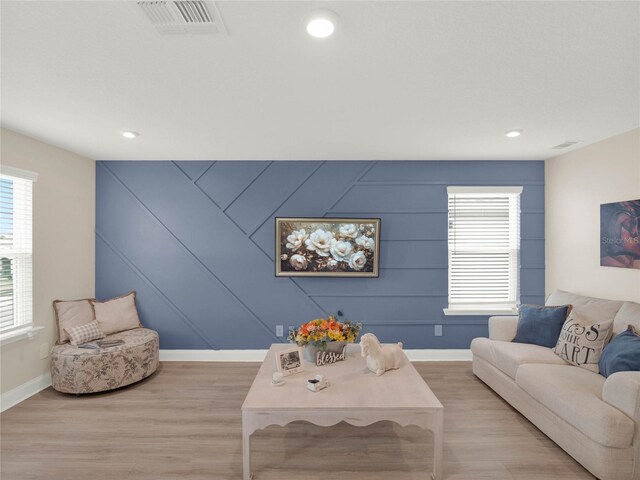 living area with baseboards, recessed lighting, visible vents, and light wood-style floors