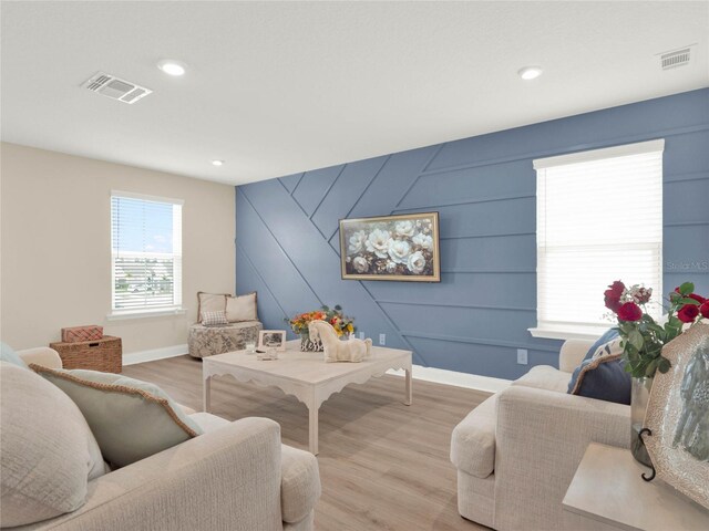 living area with light wood-style floors, baseboards, visible vents, and recessed lighting